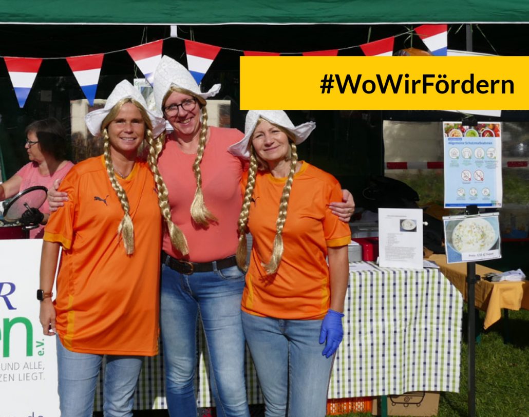 kachel-wowirfoerdern-suppenfest WoWirFördern: Suppenfest in Greiz, Frauen in Kostümen vor einem Stand mit niederländischen Flaggen