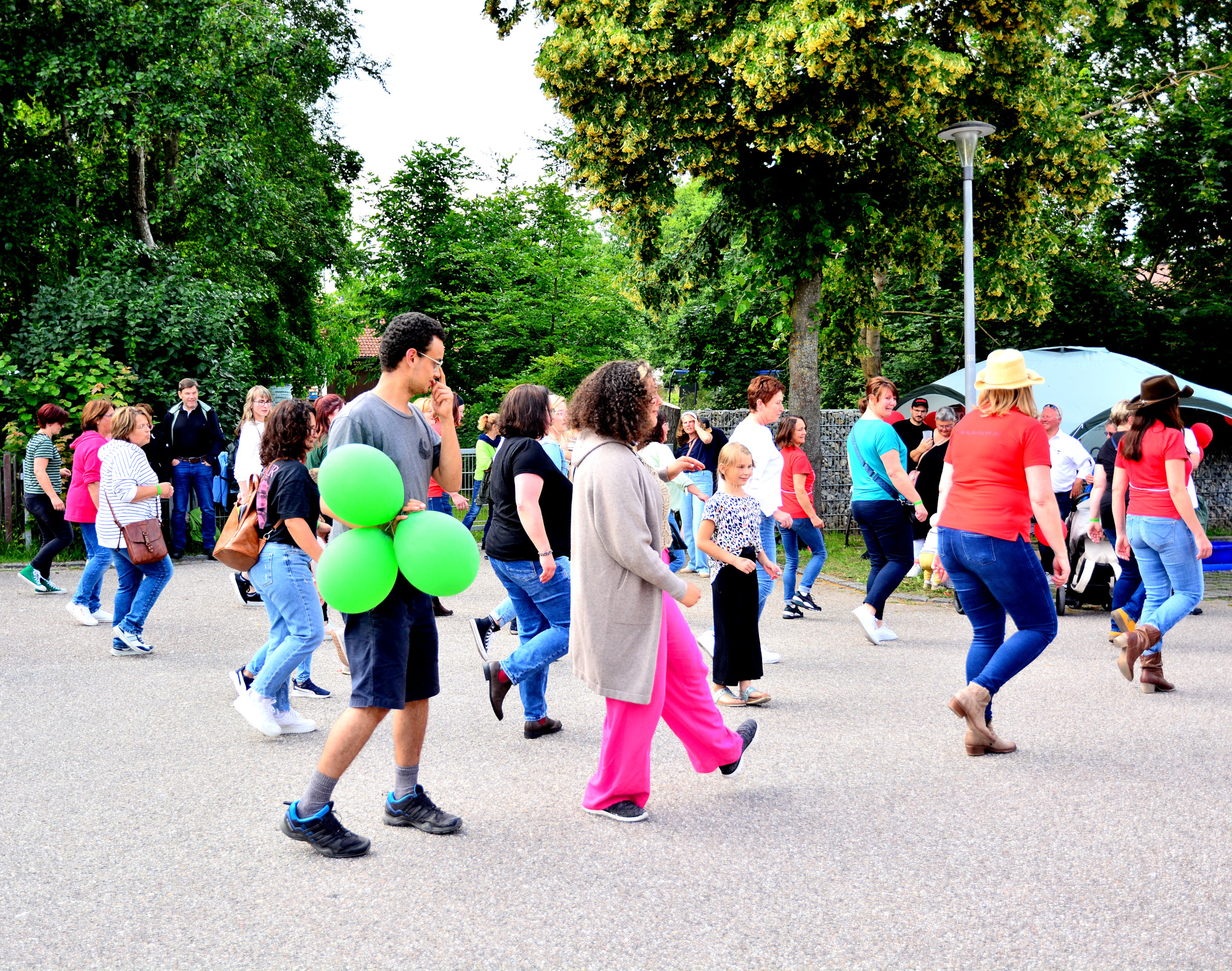 Menschen mit Luftballons tanzen unter freiem Himmel Linedance