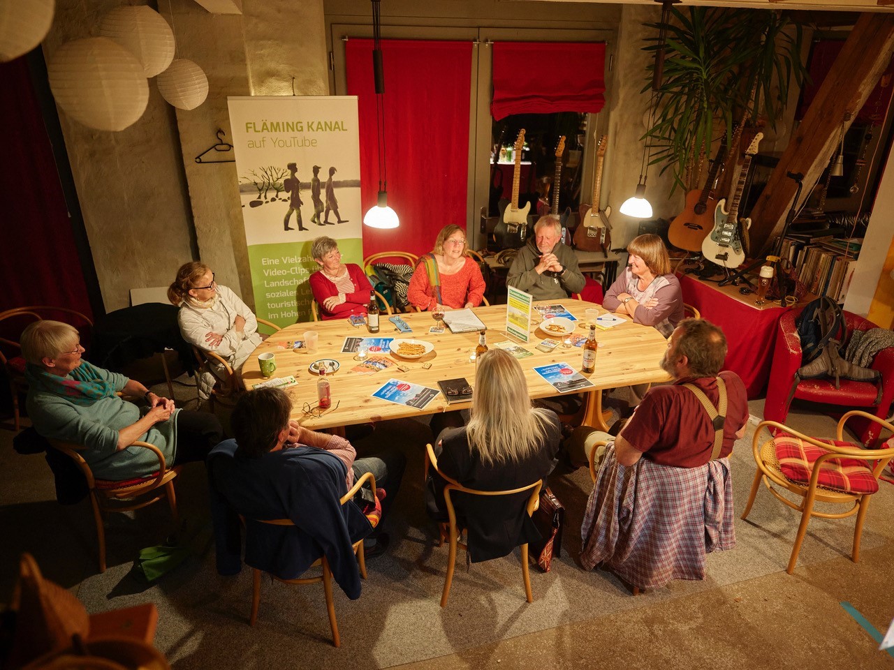Mehrere Menschen sitzen gemütlich an einem Tisch