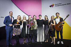 Deutscher Engagementpreis 2024 Personen des Elternnetzwerkes "Gemischte Tüte" auf einer Bühne