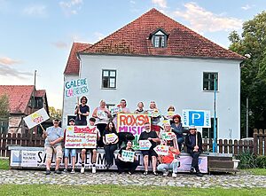 Menschen mit Schildern vorm Haus