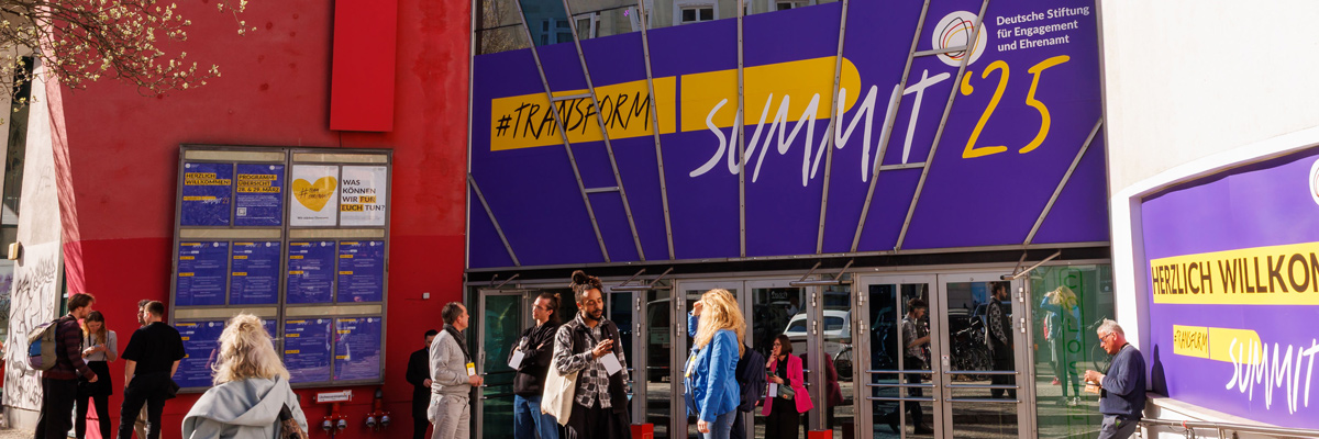 Eingangsbereich Coloseum in Berlin beim Event "Transform_D Summit 2025" mit Menschen, die sich in der Sonne unterhalten