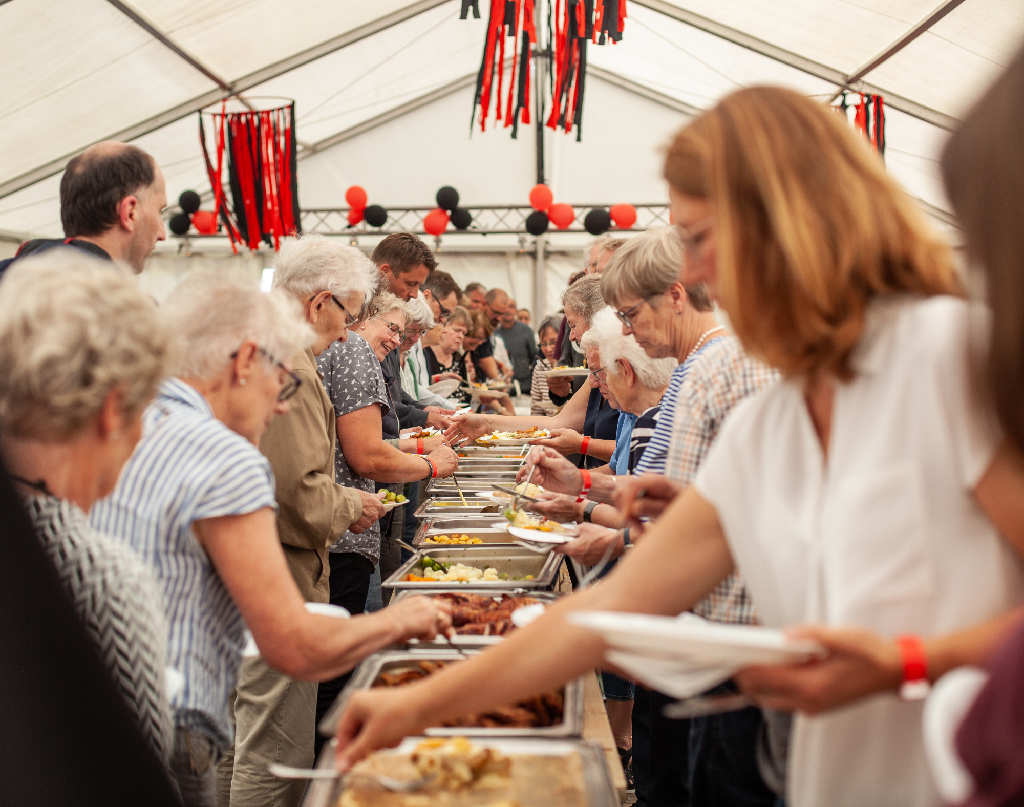 Beim Treffen des ELa-Netzwerks "Wir sind Rhade" bedienen sich Menschen an einem Buffet